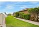 Lush green side yard with a concrete walkway and vibrant flowering bushes and colorful foliage at 2819 47Th E St, Palmetto, FL 34221