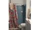 Functional bathroom featuring a shower with blue tiles, a floral shower curtain, and essential fixtures at 5231 Brassy Loop, North Port, FL 34287