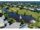 Aerial view of The Plantation's golf course and pond with water fountain, surrounded by green spaces at 802 Montrose Dr # 204, Venice, FL 34293