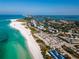Stunning aerial view of a pristine beach with clear turquoise water and a vibrant coastal community at 8697 Milestone Dr, Sarasota, FL 34238