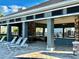 Inviting clubhouse patio with lounge chairs, outdoor seating, a built-in grill, and covered areas at 8697 Milestone Dr, Sarasota, FL 34238