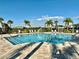 Community pool featuring clear blue water, surrounding lounge chairs, and lush landscaping at 8697 Milestone Dr, Sarasota, FL 34238
