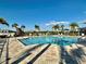 Community pool with chairs, lounge seating and palm trees on a clear sunny day at 8697 Milestone Dr, Sarasota, FL 34238