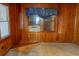 View of bedroom with wood walls, window with curtains, old rug, and carpet at 126 W North St, Tampa, FL 33604