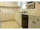 White kitchen featuring tiled countertops, tiled floor, and black dishwasher at 126 W North St, Tampa, FL 33604