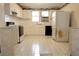 A kitchen featuring white cabinets, tiled countertops, tiled floor, and appliances at 126 W North St, Tampa, FL 33604