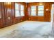 Living room featuring wood paneled walls, carpet, and a bright window at 126 W North St, Tampa, FL 33604