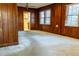 Living room featuring wood paneled walls, carpet, and a bright window at 126 W North St, Tampa, FL 33604