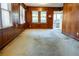 Bright living room featuring wood paneled walls, carpet, and a doorway to the screened porch at 126 W North St, Tampa, FL 33604