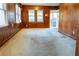Bright living room featuring wood paneled walls, carpet, and a doorway to the screened porch at 126 W North St, Tampa, FL 33604