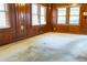 Living room featuring wood paneled walls, carpet, and a bright window at 126 W North St, Tampa, FL 33604