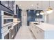 Modern kitchen with white quartz island, navy blue cabinetry, and gold accents at 2073 Treasure Ln, Punta Gorda, FL 33982