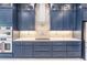 Modern kitchen with navy blue cabinetry and geometric backsplash at 2073 Treasure Ln, Punta Gorda, FL 33982