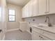 Laundry room with white cabinets, geometric floor tile, and a utility sink at 2073 Treasure Ln, Punta Gorda, FL 33982