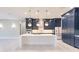Modern kitchen with white quartz island, navy blue cabinetry, and gold accents at 2073 Treasure Ln, Punta Gorda, FL 33982