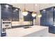 Modern kitchen with white quartz island, navy blue cabinetry, and gold accents at 2073 Treasure Ln, Punta Gorda, FL 33982