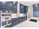 Modern kitchen with navy blue cabinetry, white quartz counters, and gold hardware at 2073 Treasure Ln, Punta Gorda, FL 33982
