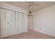 Bedroom with ceiling fan, large closet featuring white doors, and neutral carpet and walls at 3006 Caring Way # 325, Port Charlotte, FL 33952