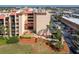 A multi-story building with a red roof, landscaping, and a parking lot at 3006 Caring Way # 325, Port Charlotte, FL 33952