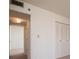 Hallway with white walls, trim, and carpet leads to closet and doorway, lit by a unique ceiling light fixture at 3006 Caring Way # 325, Port Charlotte, FL 33952