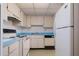 A cozy kitchen with white cabinets and appliances at 3006 Caring Way # 325, Port Charlotte, FL 33952