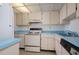 Bright kitchen featuring white appliances, cabinetry, and vintage countertops at 3006 Caring Way # 325, Port Charlotte, FL 33952