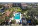 Aerial view of a pool surrounded by palm trees and condos, providing a tropical oasis for residents at 3006 Caring Way # 325, Port Charlotte, FL 33952