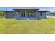 A covered back porch with gray painted concrete offering outdoor living with access to the green backyard at 3482 Dunkirk St, Port Charlotte, FL 33980