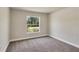 Bedroom with neutral carpet and trim, view of landscaped yard through window at 3482 Dunkirk St, Port Charlotte, FL 33980