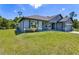View of the side of the home with well-maintained lawn and landscaping under a clear sky, showing a modern exterior and design at 3482 Dunkirk St, Port Charlotte, FL 33980