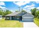 Charming single-story home featuring a two-car garage, well-manicured lawn, and neutral gray stucco exterior with a complementary roof at 3482 Dunkirk St, Port Charlotte, FL 33980