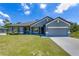 Charming single-story home featuring a two-car garage, well-manicured lawn, and inviting curb appeal at 3482 Dunkirk St, Port Charlotte, FL 33980