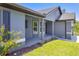 Covered front porch with gray painted concrete, decorative pillars, and fresh landscaping, offering a welcoming entry to the home at 3482 Dunkirk St, Port Charlotte, FL 33980