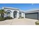 Single-story home with light gray exterior, metal roof, and two-car garage at 7417 S Moss Rose, Punta Gorda, FL 33955