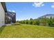 Landscaped backyard with a spacious grassy area and screened enclosure at 9445 Galaxie Cir, Port Charlotte, FL 33981