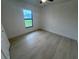 A bedroom with light hardwood floors and a window overlooking the front yard at 8285 Agate St, Port Charlotte, FL 33981