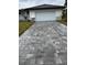 A home with a two-car garage featuring a decorative paver driveway and manicured landscaping at 8285 Agate St, Port Charlotte, FL 33981