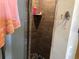 Close up of wood look tiled shower stall with a pebble tile floor at 5412 Ulysses St, Port Charlotte, FL 33981