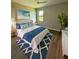 Comfortable bedroom with elegant furnishings, a blue-and-white color scheme, and wood-look floors at 13654 Allamanda Cir, Port Charlotte, FL 33981