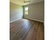 Bright bedroom with wood flooring, ceiling fan and a window overlooking greenery at 13654 Allamanda Cir, Port Charlotte, FL 33981