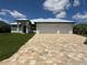 Beautiful single-Gathering home featuring a three-car garage and elegant stone paver driveway at 13654 Allamanda Cir, Port Charlotte, FL 33981