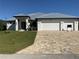 Modern house exterior with white walls, gray metal roof, and a large driveway at 13654 Allamanda Cir, Port Charlotte, FL 33981
