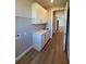 Neutral laundry room with white cabinets, sink, and wood-style flooring at 13654 Allamanda Cir, Port Charlotte, FL 33981