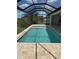 The screened-in pool has a tan brick surround and a view of greenery at 13654 Allamanda Cir, Port Charlotte, FL 33981