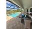 Screened in pool with an outdoor dining table and lounge seating, perfect for relaxation and entertaining at 13654 Allamanda Cir, Port Charlotte, FL 33981