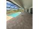 The screened-in pool area features a ceiling fan, patio and view of the neighborhood at 13654 Allamanda Cir, Port Charlotte, FL 33981