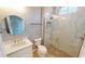 Bathroom with white vanity, round mirror, and a walk-in shower at 28944 Gin Ln, Punta Gorda, FL 33982