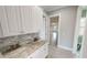 White kitchen cabinets, granite countertop, and view of garage at 28944 Gin Ln, Punta Gorda, FL 33982
