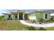 Charming single-story home with a light yellow exterior, metal roof, and landscaped walkway at 28944 Gin Ln, Punta Gorda, FL 33982