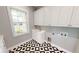 Bright laundry room with white cabinets, geometric tile floor, and window at 28944 Gin Ln, Punta Gorda, FL 33982